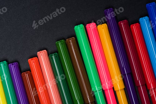 Preview: Top view of set of colorful felt tip pens on black