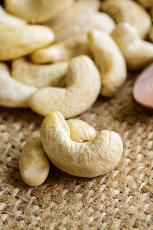 Preview: Raw cashew nuts with wooden spoon on sackcloth
