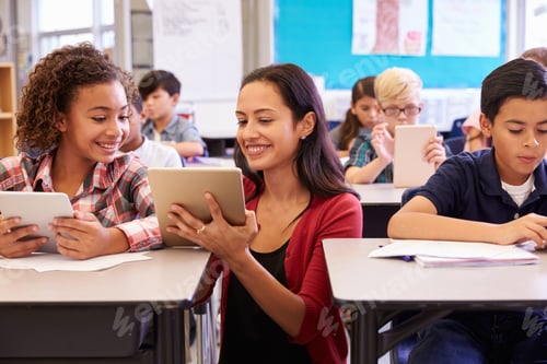 Preview: Teacher helping kids with computers in elementary school
