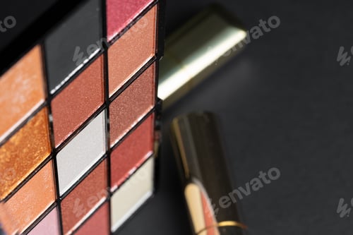 Preview: various makeup products on black texture background.
