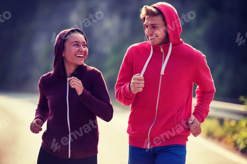 Preview: young couple jogging along a country road
