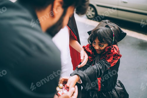 Preview: Child in costume receiving treats on a festive day