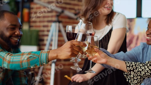 Preview: Close up shot of wine glasses being toasted at home party by multiethnic group of people