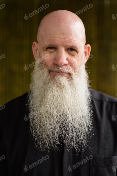 Preview: Portrait of man bald man with long gray beard outdoors against bamboo wall