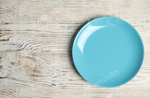 Preview: Empty light blue plate on white wooden table, top view. Space for text