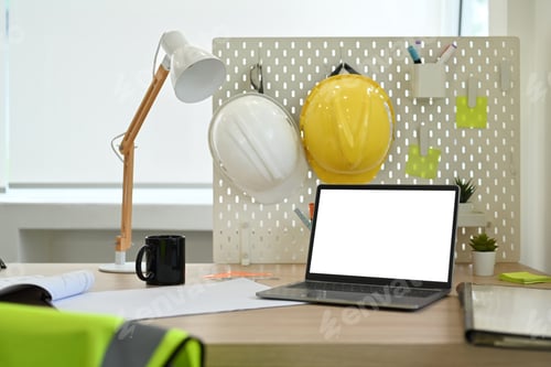 Preview: Laptop computer with blank screen, blueprints, hardhat and jacket on wooden table.