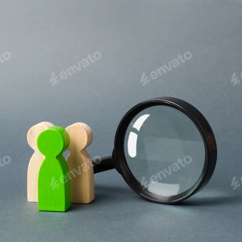 Preview: Three wooden human figure stands near a magnifying glass on a gray background