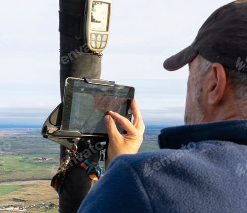 Preview: Hot air balloon pilot looking at gps from the air
