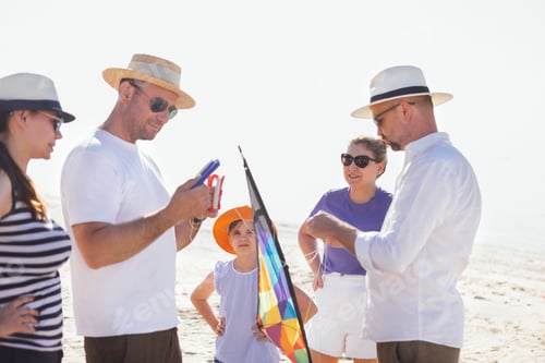 Preview: A group of friends are flying a kite on the seashore.