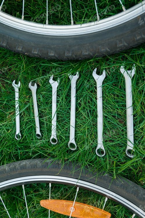 Preview: Tools, instrument for repairing bike on the wooden background outdoor wheel. Bicycle repair.