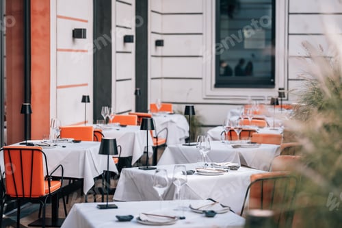 Preview: Seating area of a restaurant, with tables and chairs arranged in a pleasant outdoor setting