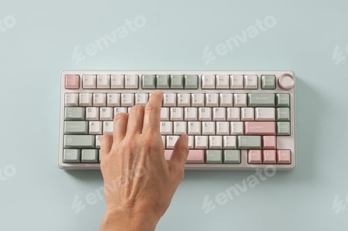 Preview: Female hand typing on keyboard on blue background. View from above. Flat lay.