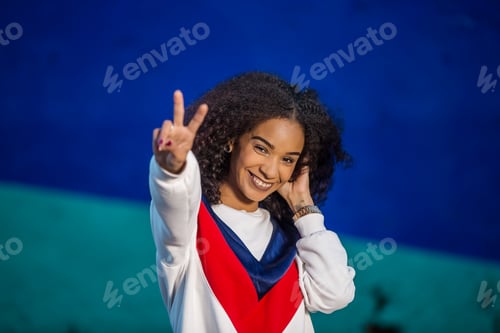 Preview: Happy stylish woman showing two fingers