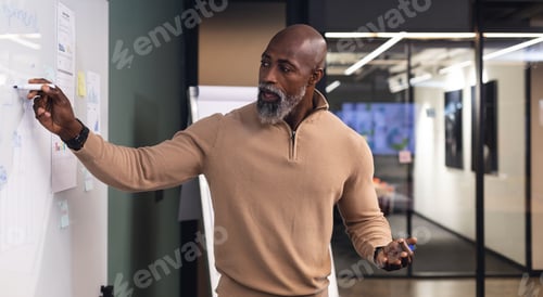 Preview: African american mature businessman explaining business strategy over whiteboard