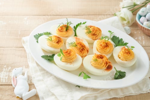 Preview: Easter stuffed eggs. Traditional Easter brunch or dinner with stuffed eggs with paprika, carrot cake