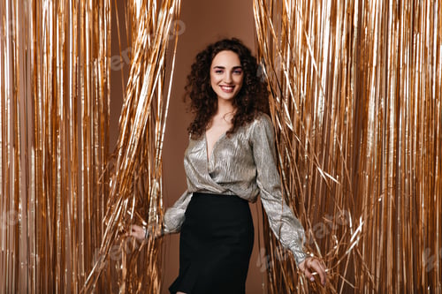 Preview: Smiling girl in silver outfit happily poses on gold background