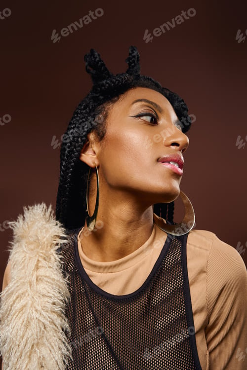 Preview: Beautiful young woman showcases unique style with braided hair and striking jewelry while posing.