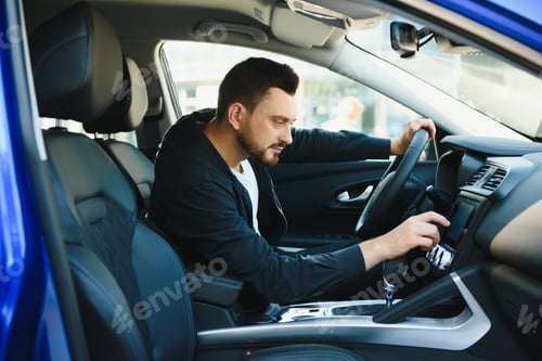 Preview: Test drive for auto. Pleasant overjoyed handsome boy holding steering wheel and driving