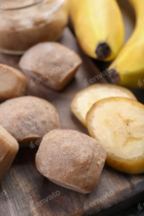 Preview: Frozen banana puree cubes and ingredient on wooden board, closeup