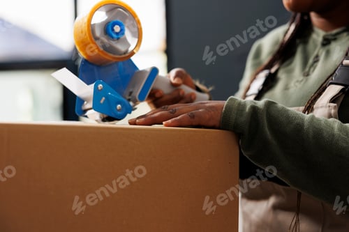 Preview: Cheerful worker putting adhesive tape on cardboard box