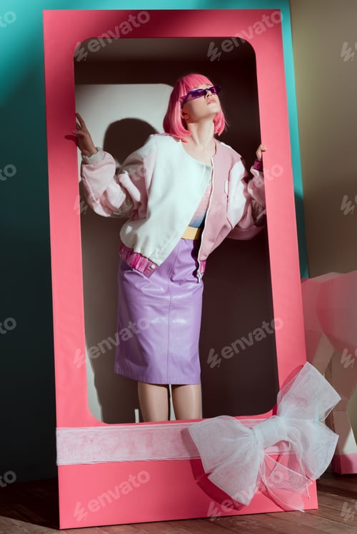 Preview: beautiful young woman in pink wig posing in decorative box with bow