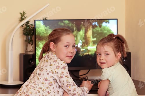 Preview: Two cute sister girls play a video game and look back at their mother who took them by surprise