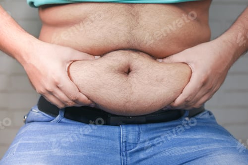 Preview: man's hand holding excessive belly fat, overweight concept