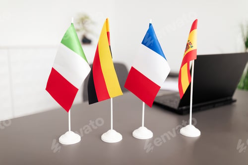 Preview: Multinational flags displayed on a desk in a modern corporate office setting