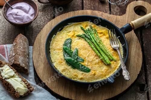 Aperçu: Frittata with green asparagus, pea on frying pan, top view, rustic style