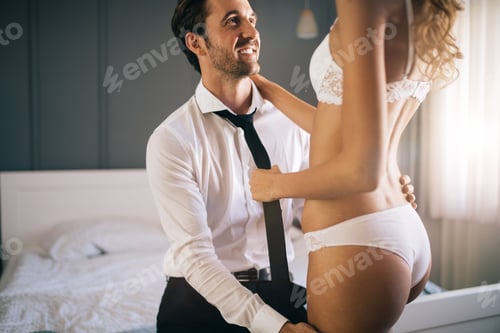 Preview: Attractive couple sharing intimate moments in bedroom