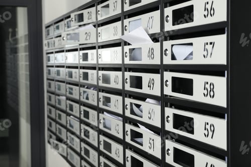 Preview: New mailboxes with keyholes, numbers and receipts near entrance in post office