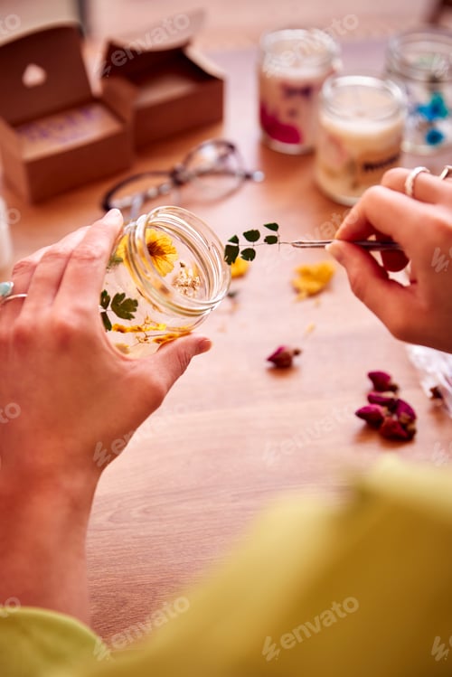 Visualização: Close-up de mulher fazendo velas de flores boutique para vender on-line trabalhando em casa