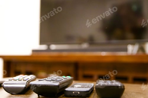 Preview: multiple remote controls lined up with TV in background