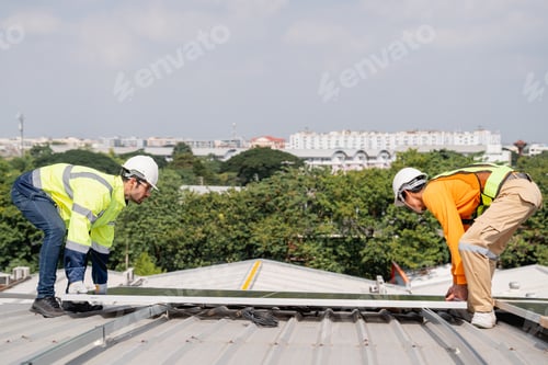 Preview: Service engineer installing solar cell on the roof of factory. Clean and Renewable energy concept.