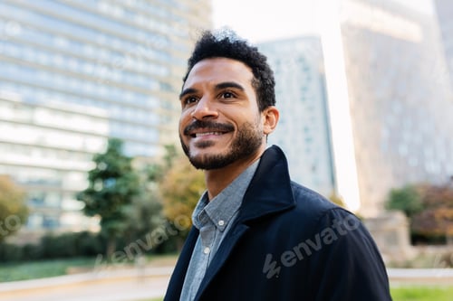 Preview: Portrait of smiling young adult Latin American businessman at city park