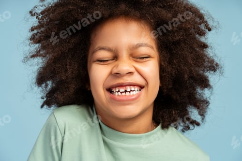 Preview: Close up of happy curly African American girl with closed eyes posing in studio