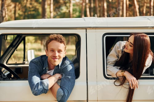 Preview: Sitting in the car. Young couple is traveling in the forest at daytime together