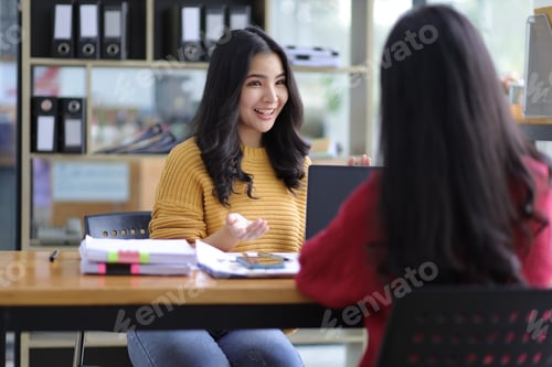 Preview: Happy businesswoman colleagues discussing in the office.