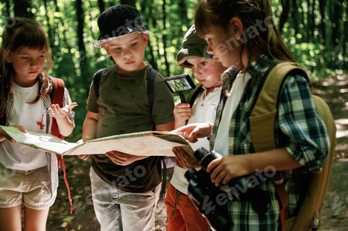 Preview: Paper traditional map. Kids in forest at summer daytime together
