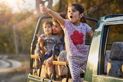 Preview: Excited child pointing out something on a family car trip.