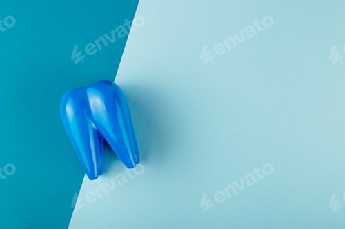 Preview: Large blue tooth lies on combined blue background. Copyspace