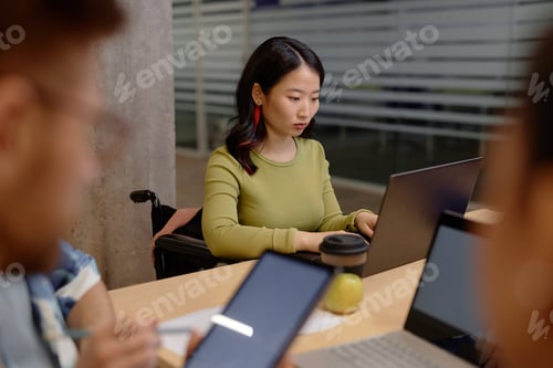 Preview: Wheelchair User Writing on Computer at University Class