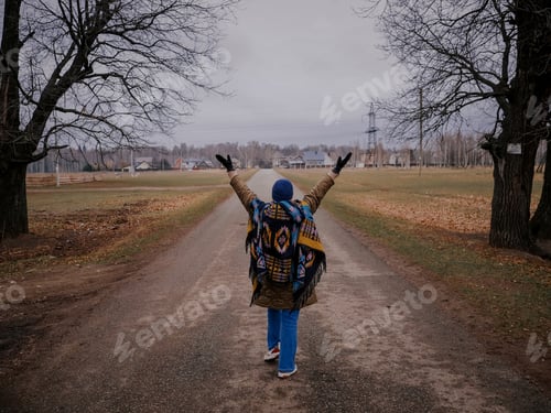 Visualização: Mulher adulta de cinquenta anos viaja na natureza no outono perto do campo. Visão traseira.