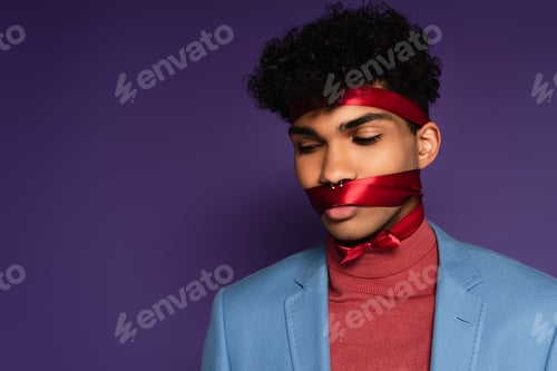 Preview: young african american man tied with red ribbon on purple