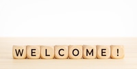 Preview: Wooden Blocks Spelling Welcome on Light Wooden Surface