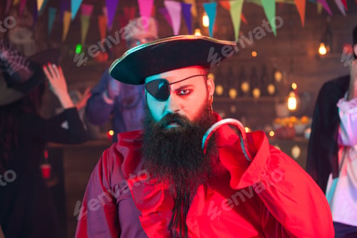 Preview: Portrait of man dressed up like pirate looking angry at the camera while celebrating halloween