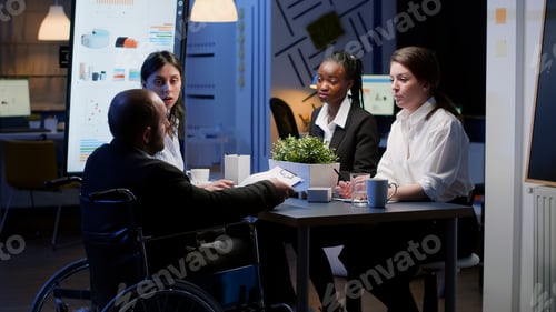 Preview: Paralyzed businessman in wheelchair is ignored while working in business office meeting room