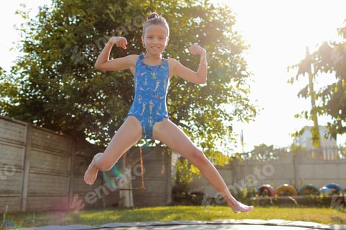 Preview: little sports girl jumps on a trampoline. Outdoor shot of girl jumping on trampoline, enjoys