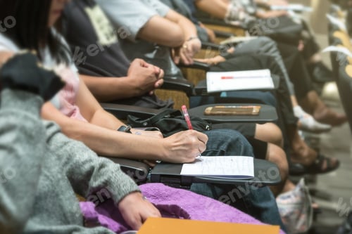 Preview: Close up shot of woman hand writing on the paper at the table in the conference hall