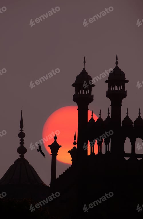 Preview: Close up of finials and lanterns on roof of Indian monument at full moon.